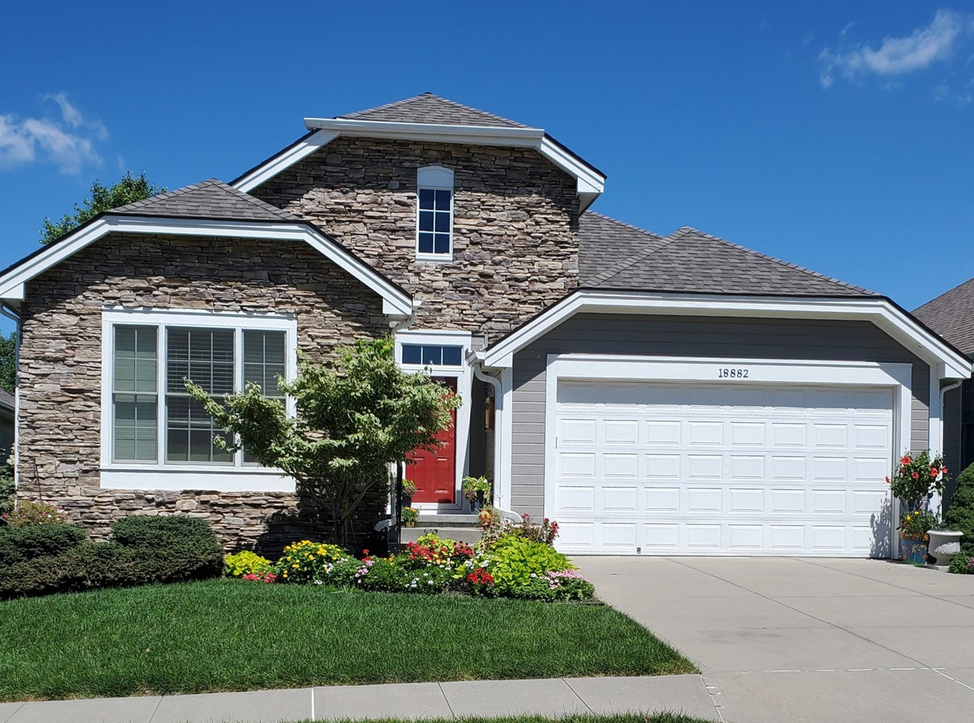 A well-kept villa home with stonework and a landscaped front yard